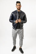 Men's Axel Coat: Glossy navy blue puffer bomber jacket with striped ribbed cuffs, paired with grey cargo joggers.