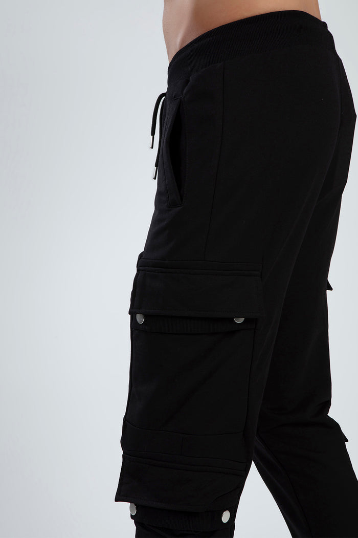 Close-up of Carbon Jeans Benjamin black cargo pants for men featuring silver snap-button pockets and drawstring waist.