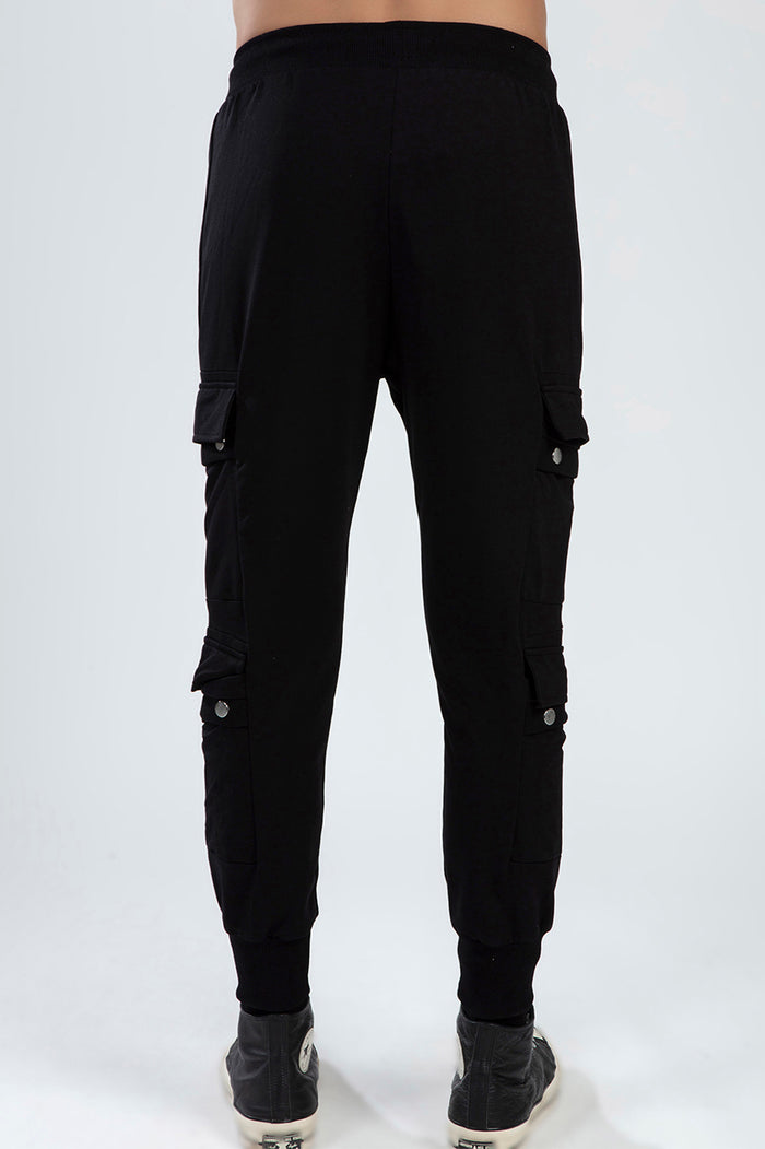 Back view of Benjamin Pants: black slim-fit streetwear cargo pants with snap-flap pockets and ribbed cuffs.