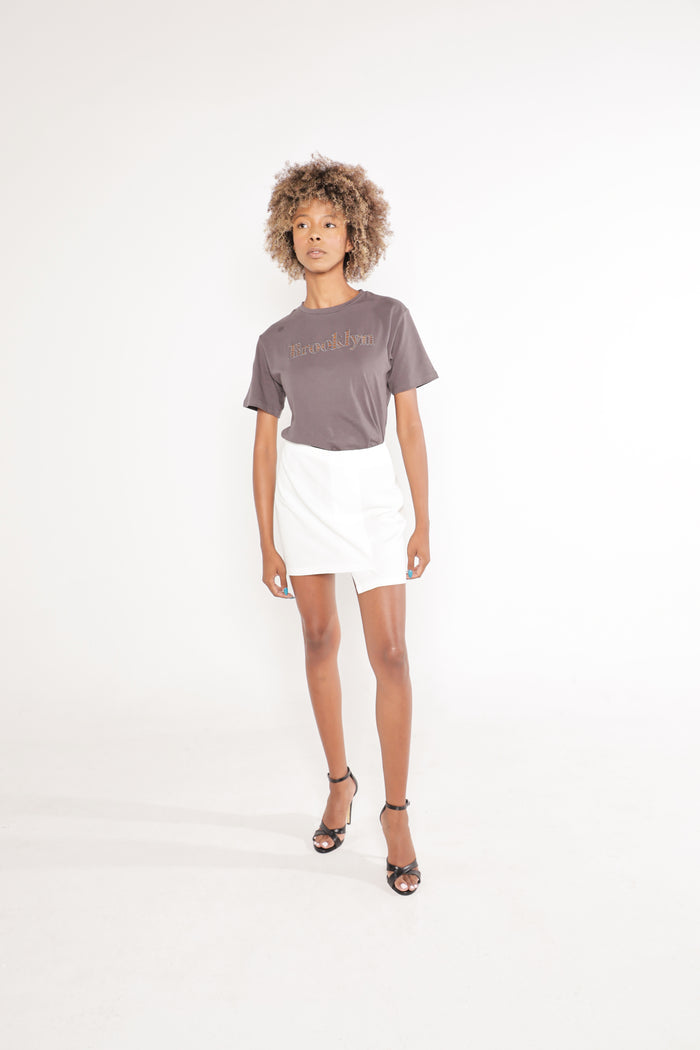 Model in Brooklyn Graphic Tee in Carbon grey streetwear style, paired with white mini skirt and black heels.