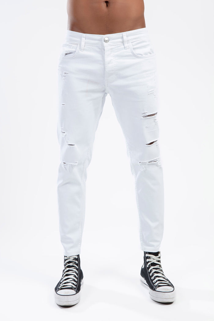 Men's Carlos white slim fit distressed jeans with streetwear-style knee rips and black high-top sneakers.