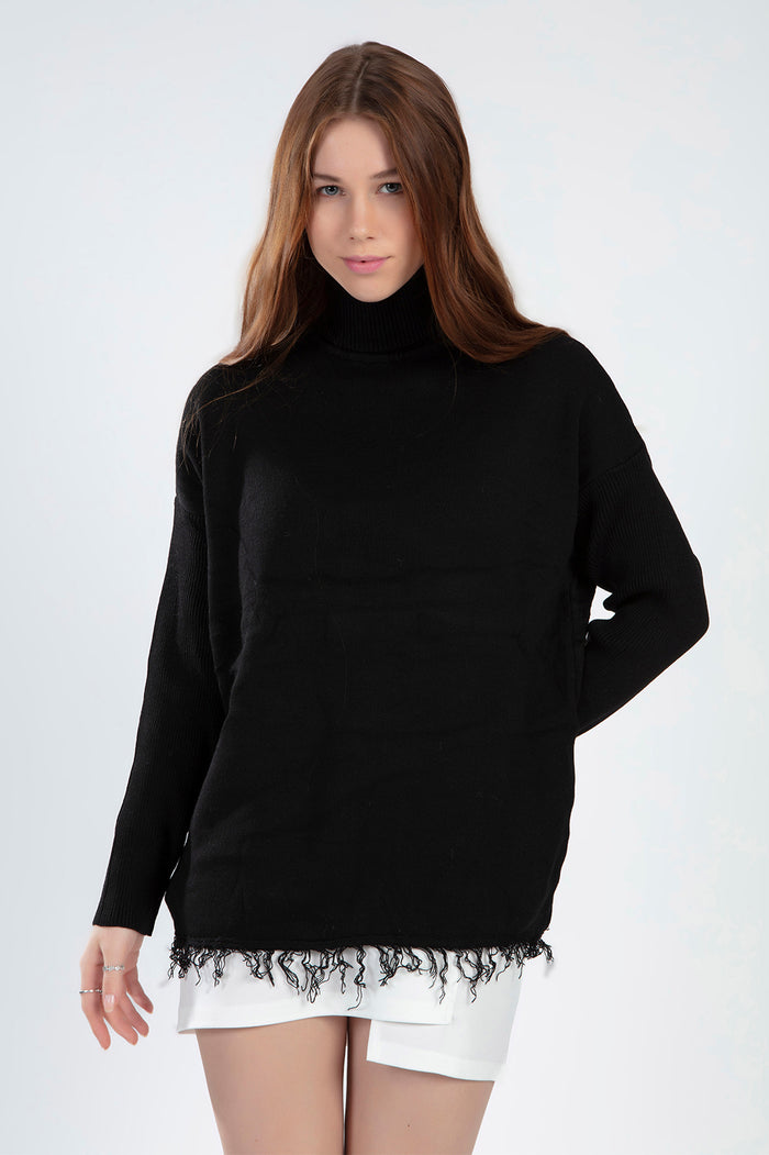 Model wearing a Celine black oversized knit turtleneck sweater with a unique distressed fringe hem against a white backdrop.