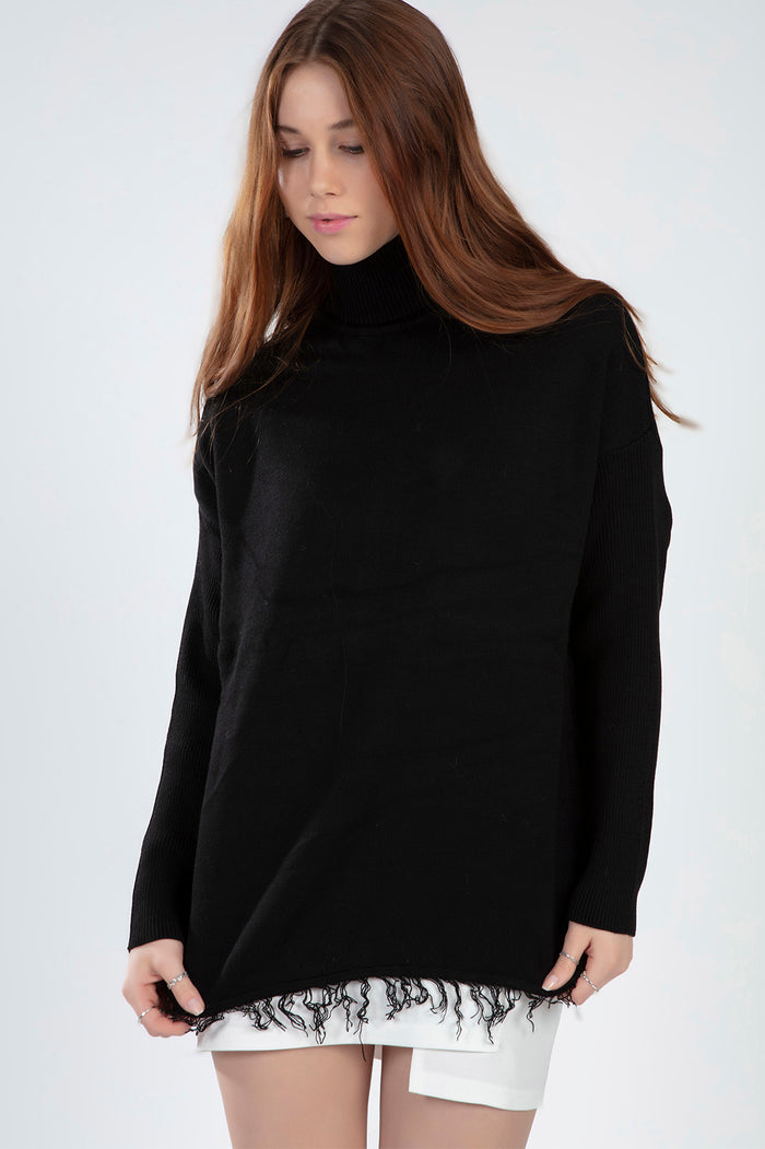 Model wearing the Celine black oversized turtleneck knit sweater with a trendy distressed fringe hem.