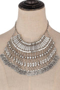 Silver-tone multi-strand coin statement necklace with layered etched coin fringe and a bohemian collar shape.