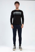 Model wearing Colin slim-fit men's evening pants in dark navy with decorative chain detail and black graphic long-sleeve.