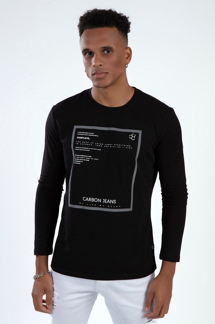 Man wearing a black long-sleeve streetwear t-shirt with a white graphic text box and Carbon Jeans logo on the chest.