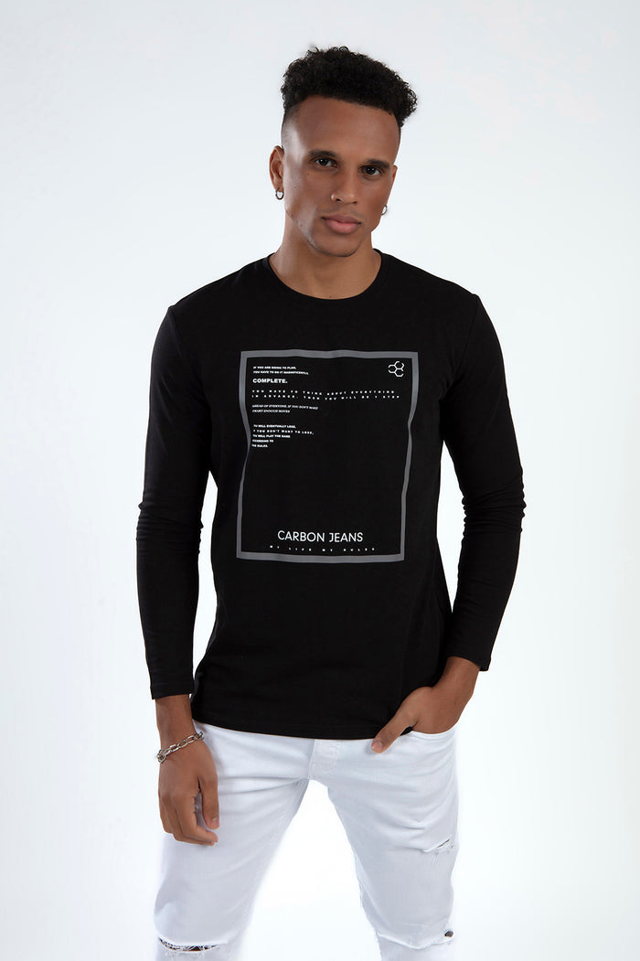 Man in a black long-sleeve streetwear shirt with a graphic box print and white distressed jeans.