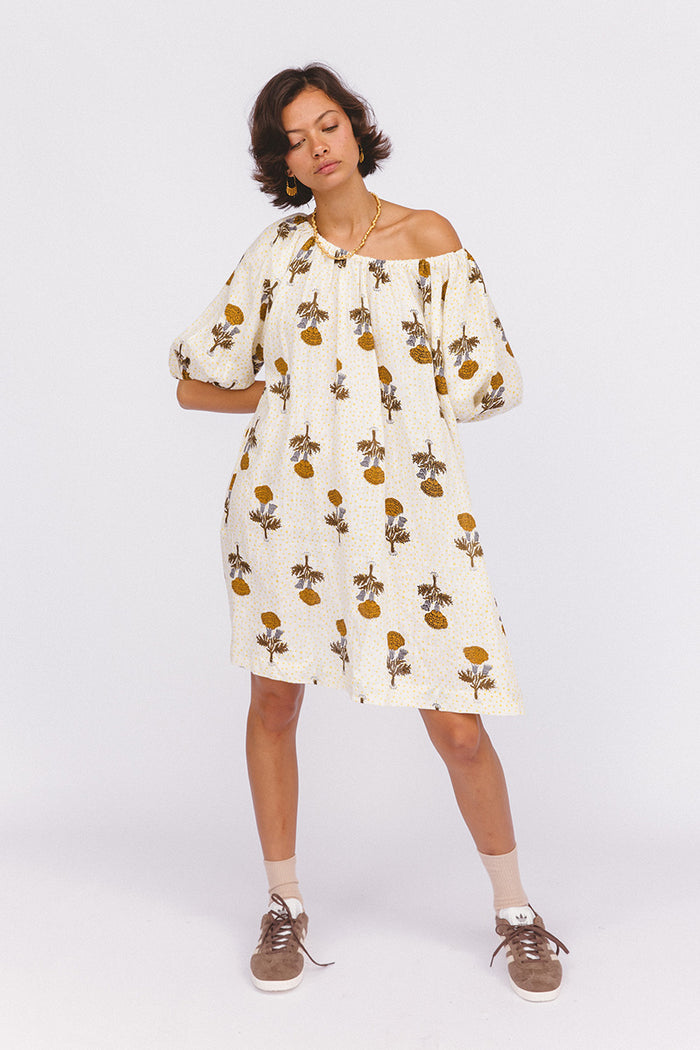 Dahlia Mini Dress Marigold — studio model off-shoulder, full length front view, white linen mini with golden marigold botanical hand block print, loose billowy silhouette, ethical boho fashion | Daughters of India