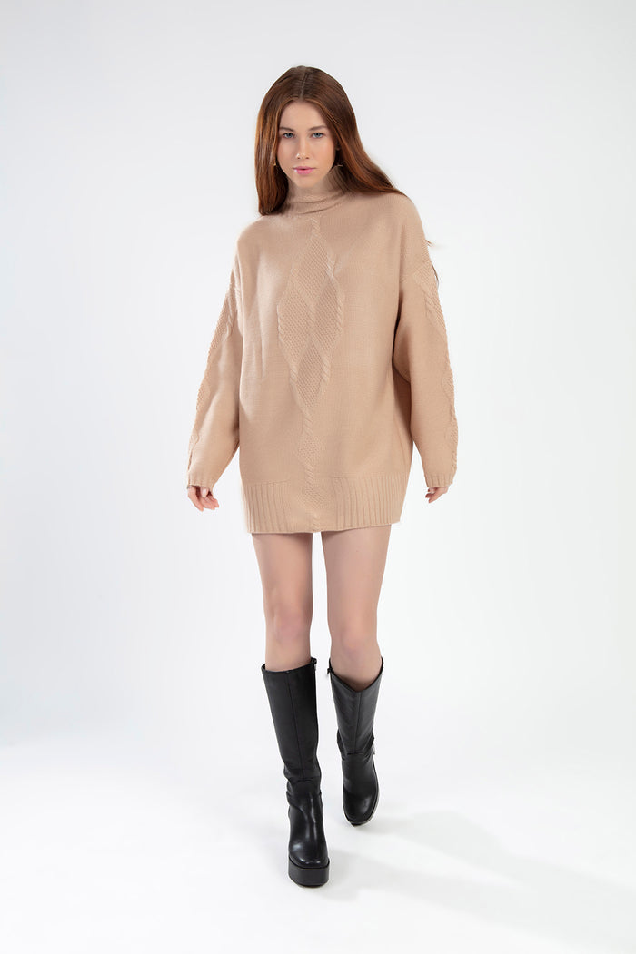 Model wearing the Destiny beige oversized cable knit turtleneck sweater with black knee-high boots.