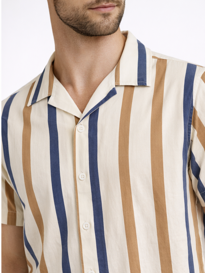 A close-up of a man wearing a short-sleeve shirt featuring vertical stripes in beige, brown, and blue.
