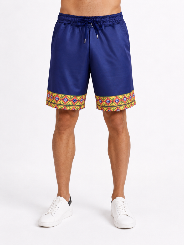 Navy blue shorts with a colorful geometric pattern at the hem, paired with white sneakers.