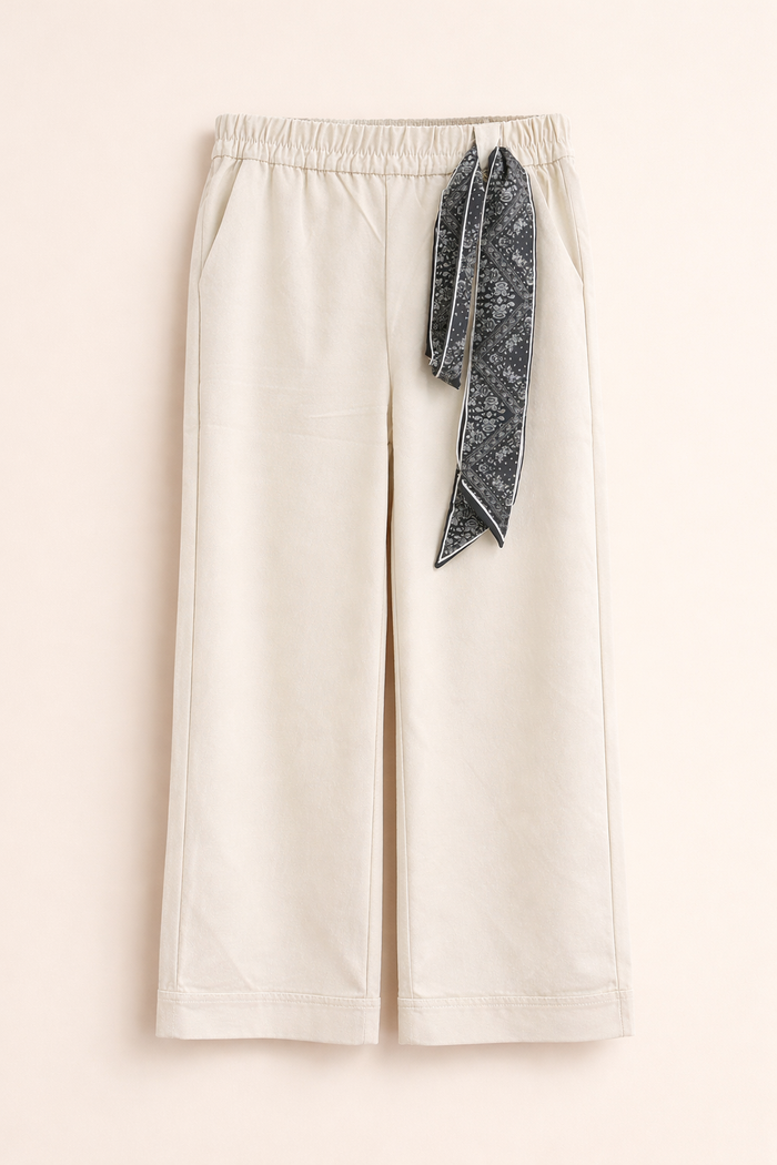 White pants with a decorative black and white patterned ribbon.