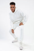 Man wearing the white Eric ribbed hoodie set with matching joggers in a diagonal knit streetwear aesthetic.