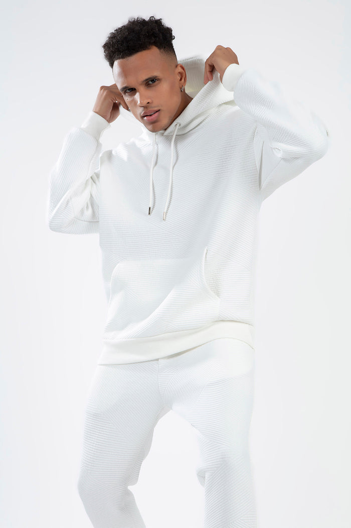 Man wearing the white Eric Hoodie Set in diagonal ribbed knit fabric, featuring a drawstring hood and matching joggers.