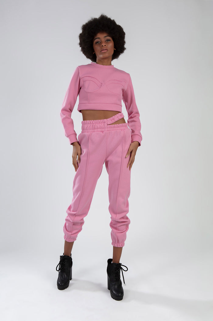 Model wearing a pink Eyes Pants Set with a cropped long-sleeve top and matching joggers in a two-piece streetwear style.