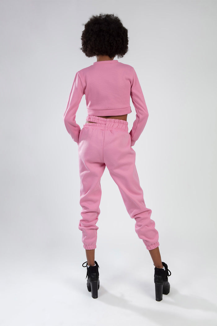 Back view of a woman wearing the pink Eyes Pants Set, featuring a cropped sweatshirt and matching high-waisted joggers.