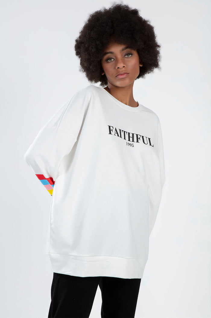 White oversized Faithful 1995 sweatshirt with rainbow striped sleeves on a model, Gen Z trendy streetwear style.