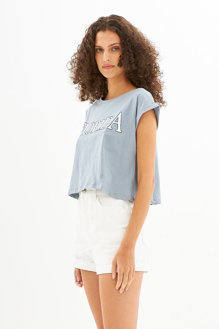 Model wearing the teal Florida Ribbed Crop Top with white high-waisted shorts, focusing on the soft-touch fabric texture.