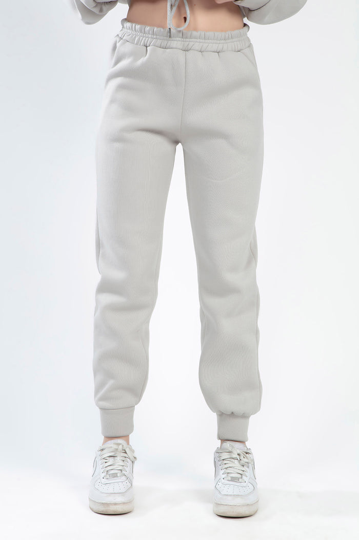 Model wearing the Freya light grey ribbed pants set, featuring high-waisted joggers with an elastic waistband and cuffs.