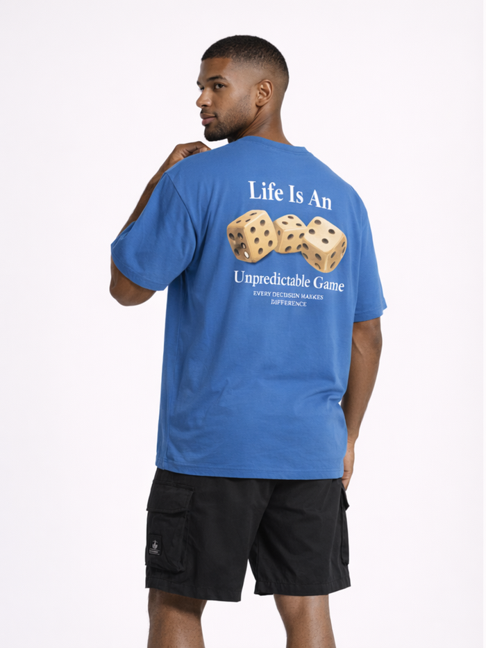 A man wearing a blue t-shirt with a graphic of dice and text about life's unpredictability.