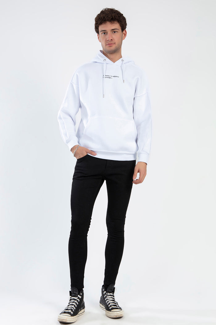 Male model wearing the White I AM Hoodie with chest text, black skinny jeans, and high-top sneakers.