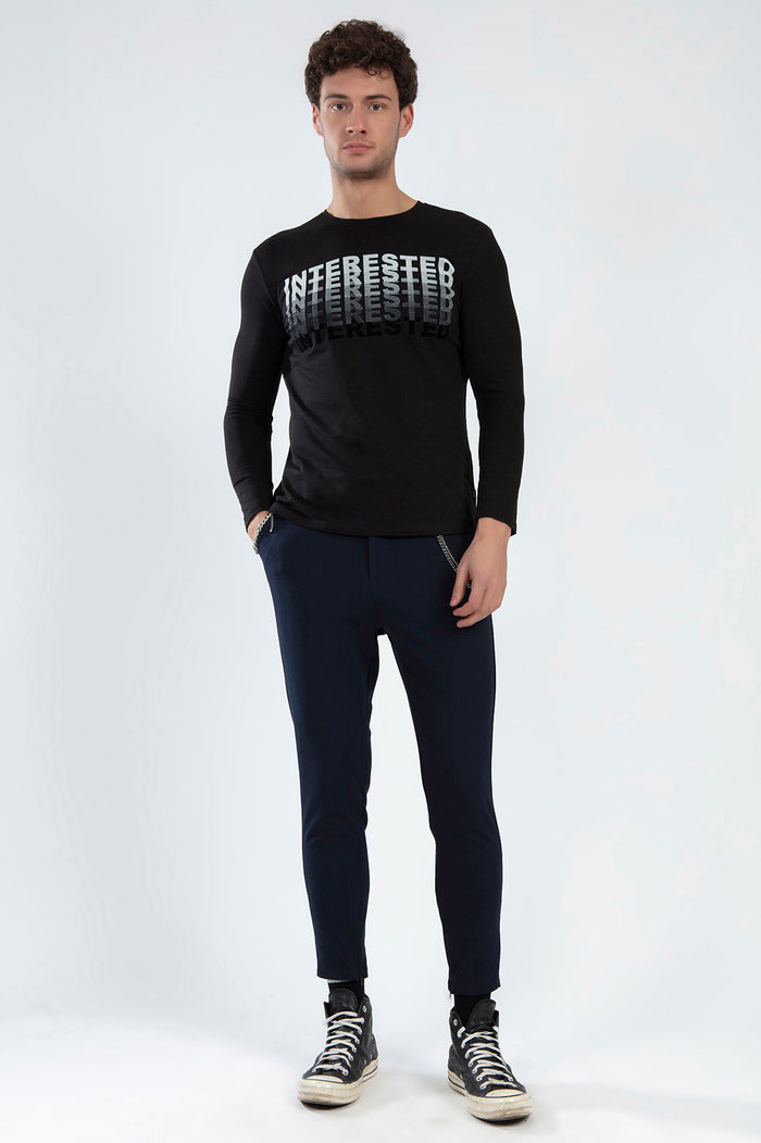 Model wearing the Interested long sleeve black shirt with urban gradient graphic, paired with navy trousers.