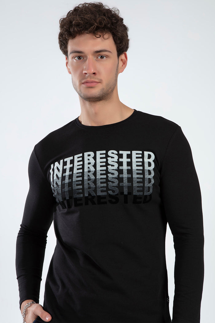Man in a black long-sleeve Interested shirt with a grey ombre graphic print, featuring a trendy relaxed-fit streetwear style.