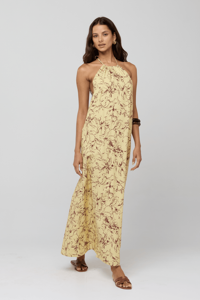 This is an image of Iris Halter Dress in Butterscotch - RESA featuring a model wearing the dress