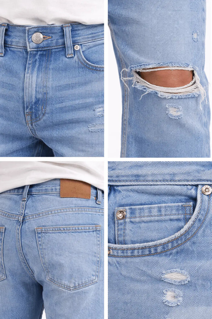Light blue denim jeans featuring distressed details, a button closure, and a brown leather patch on the back.