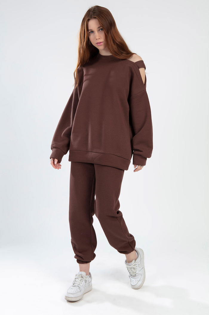 Jolene brown matching two-piece set featuring a shoulder cutout sweatshirt and oversized sweatpants.