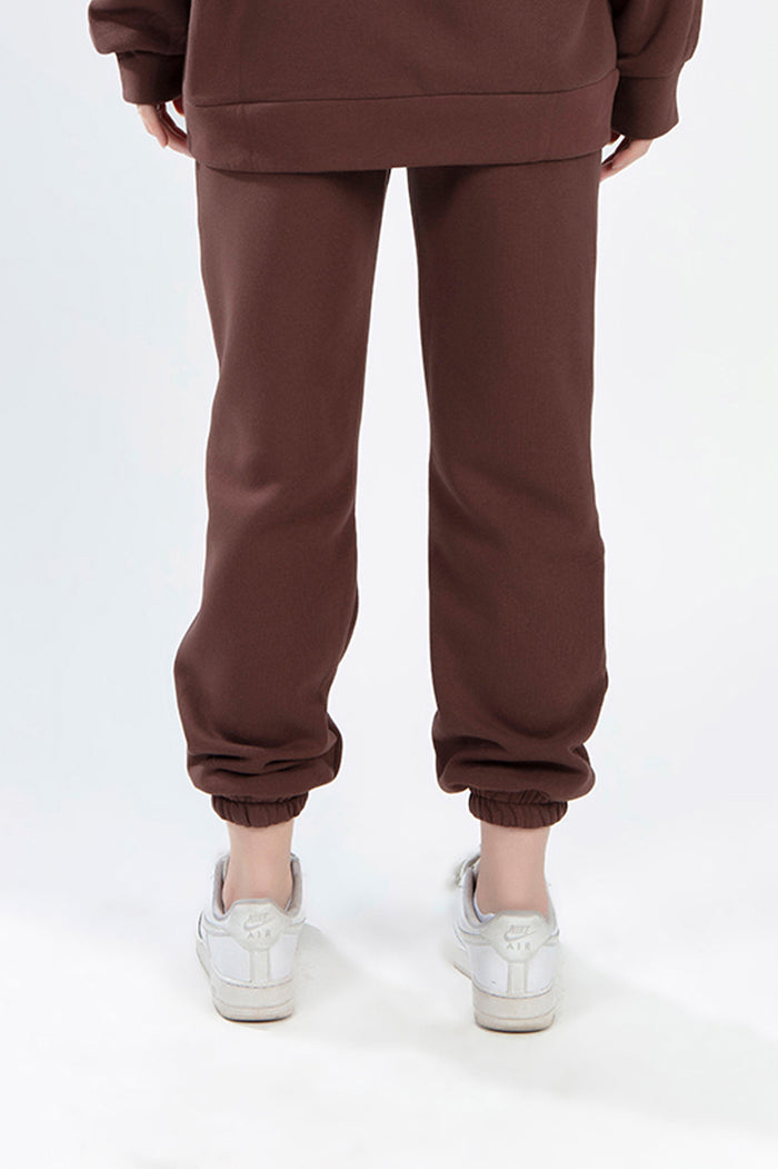Rear view of Jolene Burgundy two-piece set featuring cuffed joggers and matching sweatshirt with white sneakers.