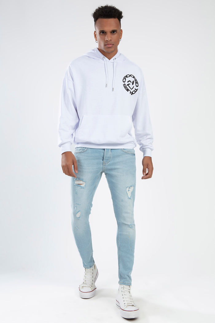 Model wearing Leon Light Blue Super Skinny Fit distressed jeans with a white hoodie and sneakers for a streetwear look.