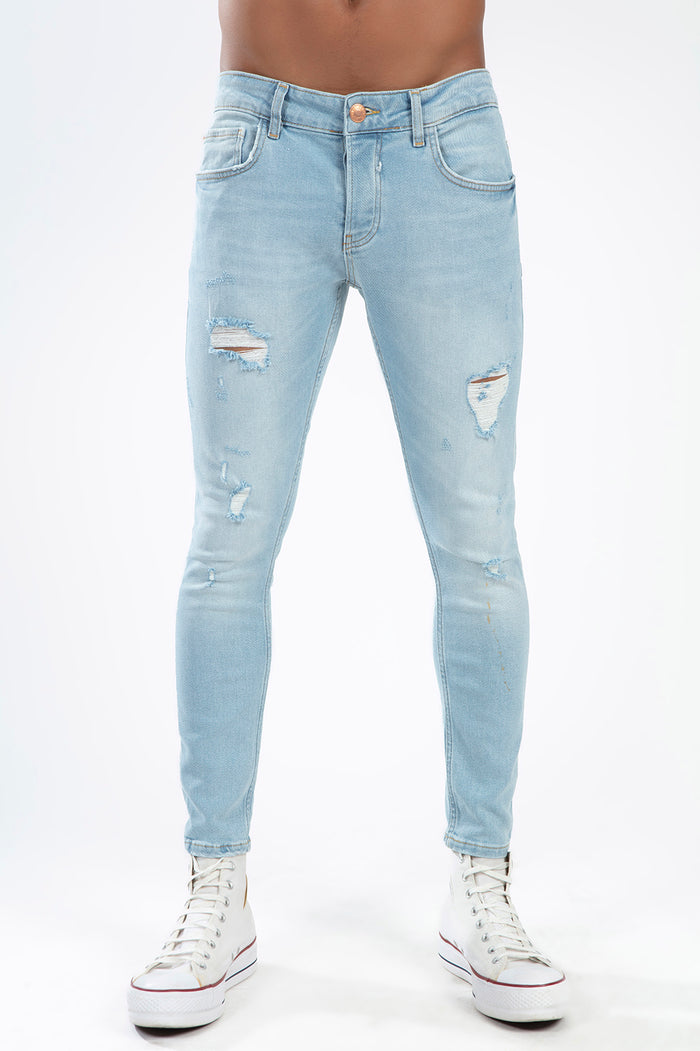 Model wearing Leon light blue super skinny jeans with distressed details, styled with white high-top sneakers.