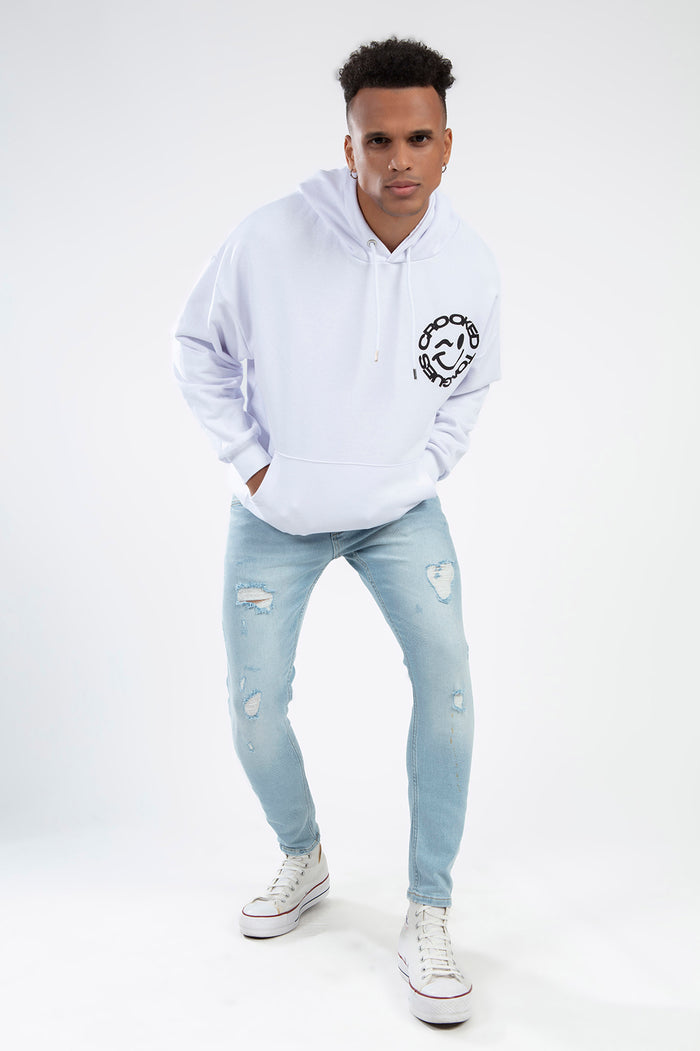 Model in light blue Leon super skinny distressed streetwear jeans, white graphic hoodie, and white sneakers.