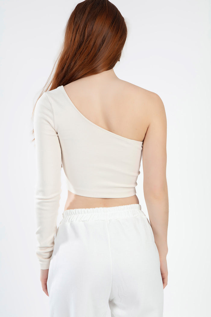 Back view of the Lexie one-shoulder ribbed crop top in nude, styled with white jogger sweatpants for a Gen Z aesthetic.
