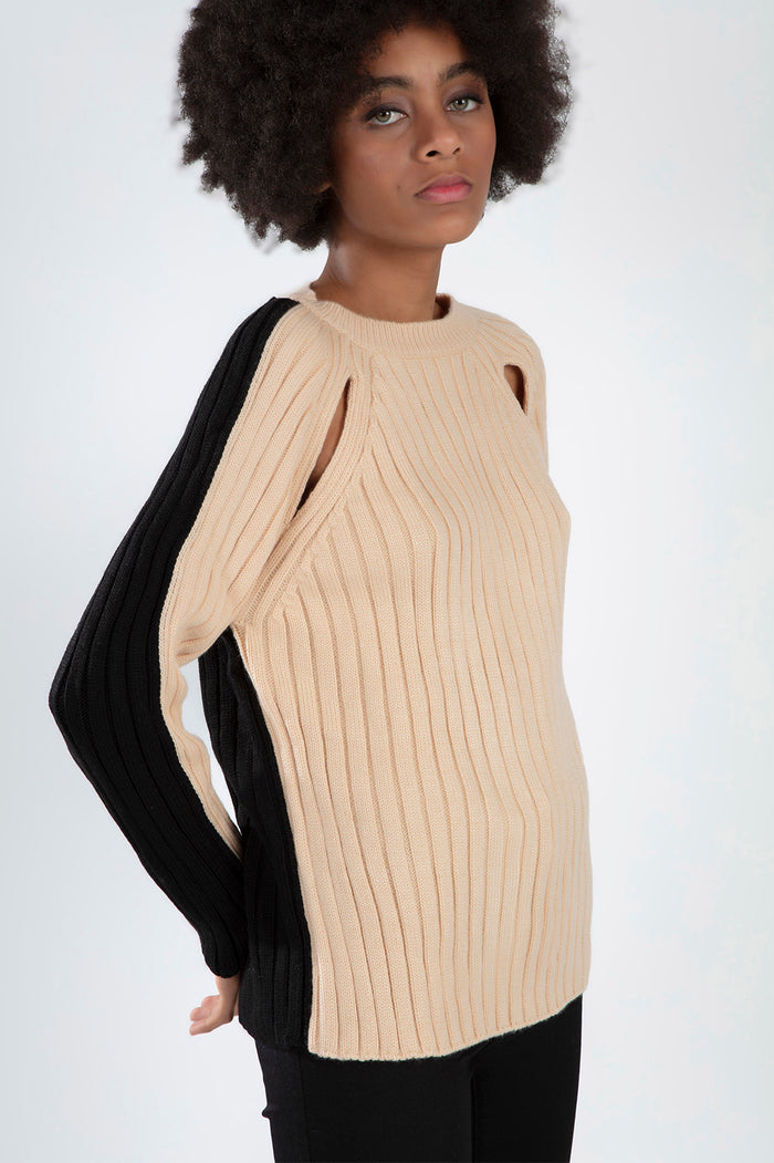 Beige and black ribbed Lilith Sweater featuring shoulder cut-outs and a crew neck on a woman with an afro.
