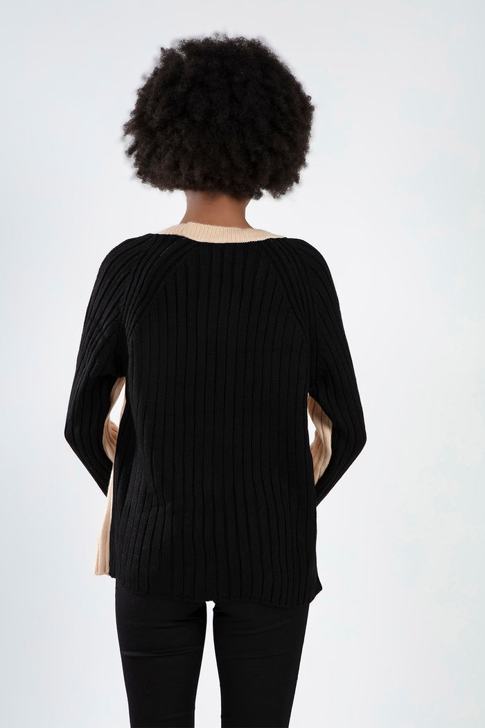 Back view of the Lilith Sweater in black ribbed knit with cream accents and a comfortable, oversized fit.