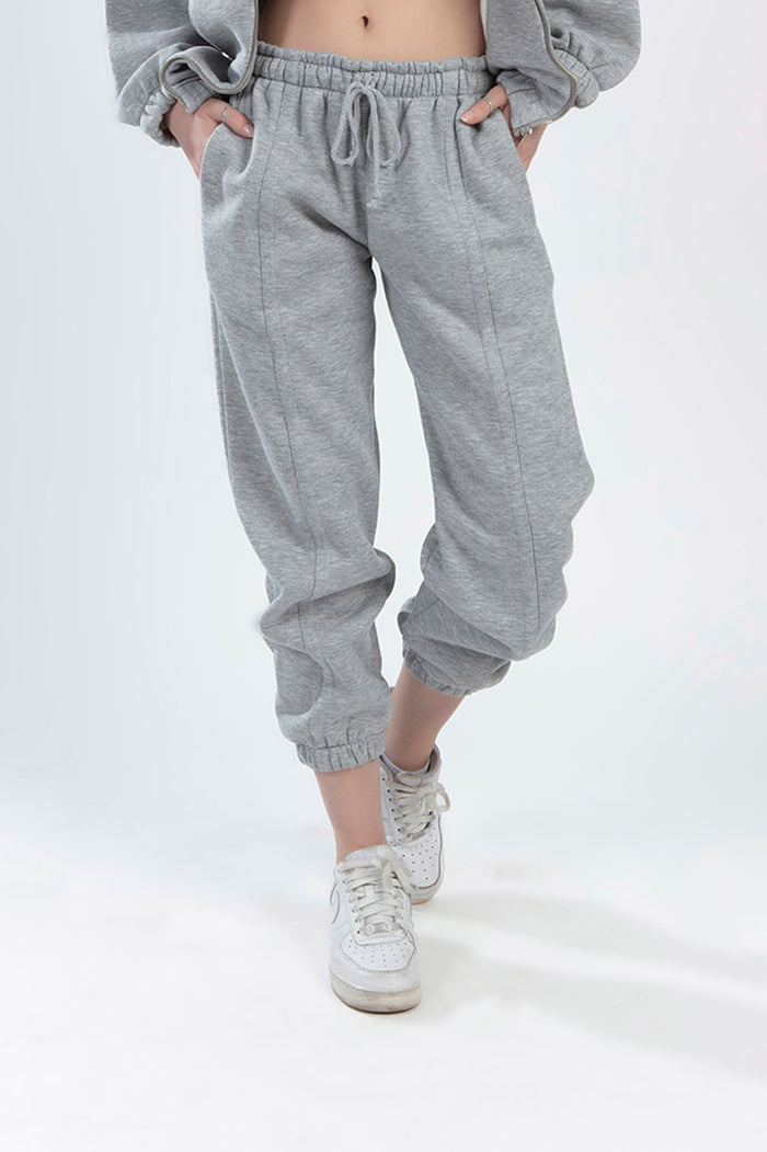 Model wearing Lily Jacket Set light grey joggers with drawstring waist, elastic cuffs, and matching cropped zip jacket.