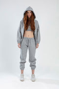 LILY PANTS SET: Light grey three-piece loungewear featuring a zip-up hoodie, crop top, and drawstring joggers.