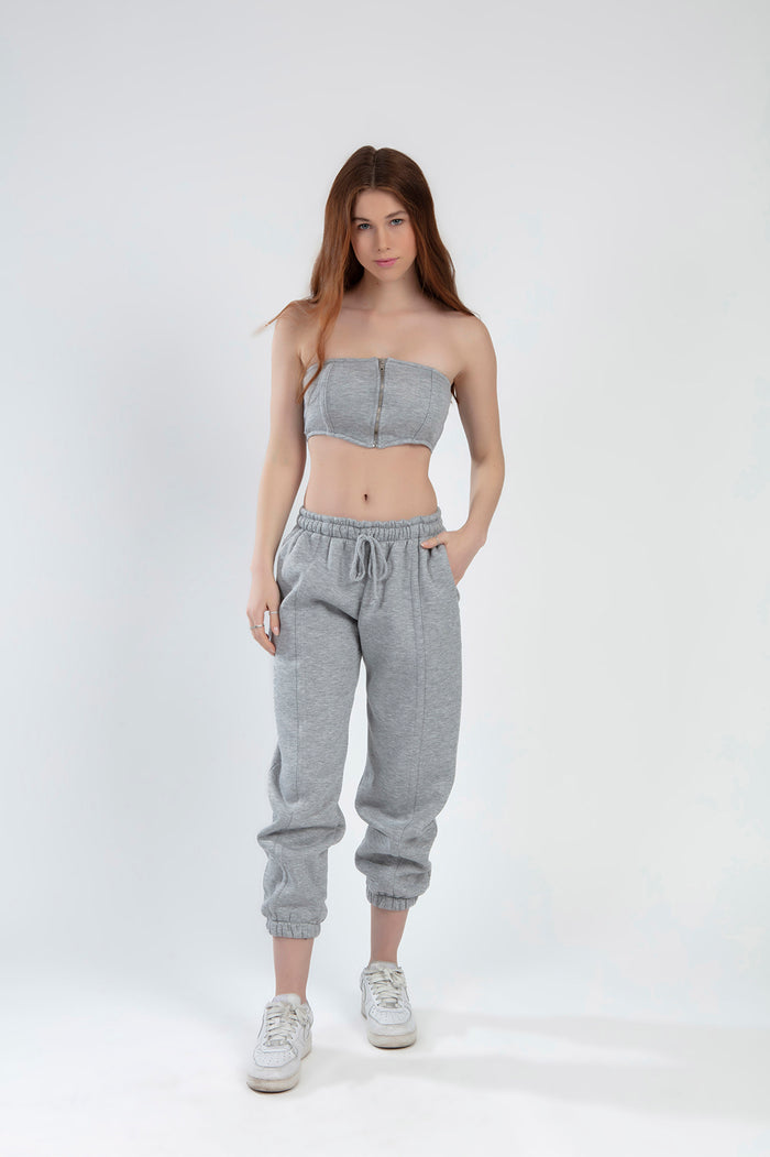 Model wearing the Lily Top Set in light grey featuring a zip-front tube top and matching drawstring jogger sweatpants.
