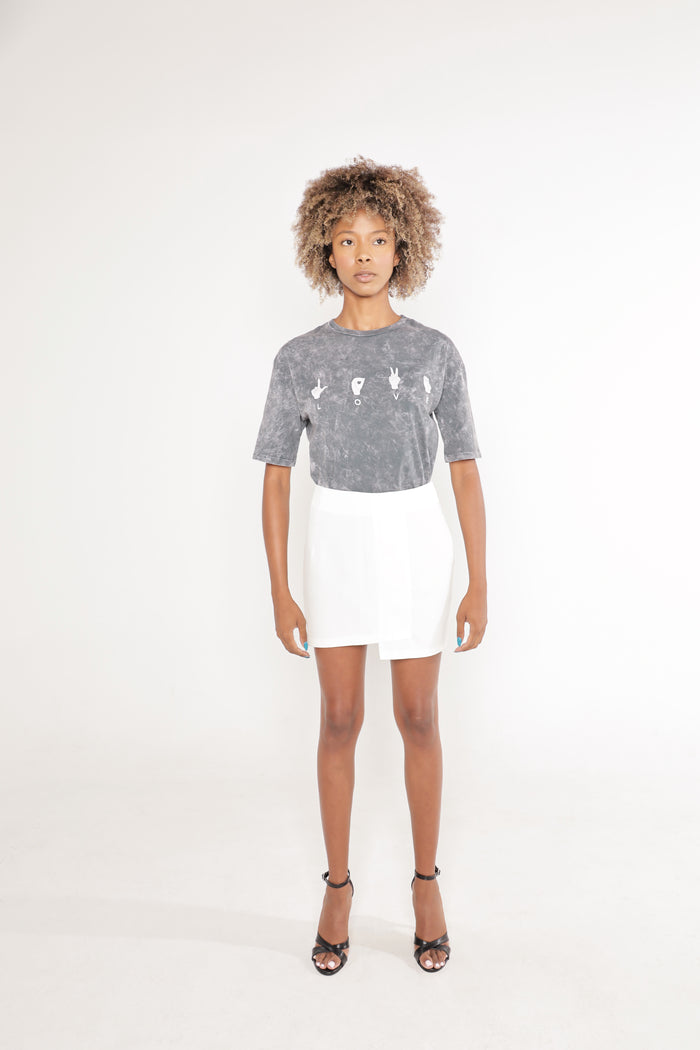 Gray acid wash Love Tee featuring ASL sign language graphics, worn by a model in a white skirt.
