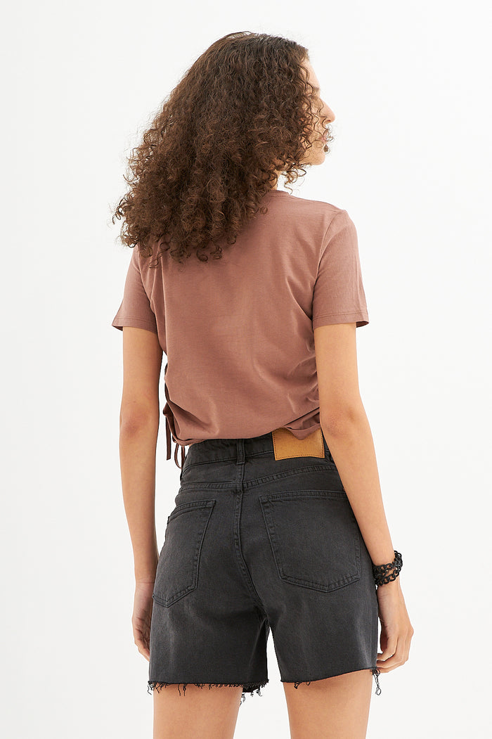 Back view of woman in Lucy Side String Brown Crop Top and black denim shorts, aesthetic streetwear style.
