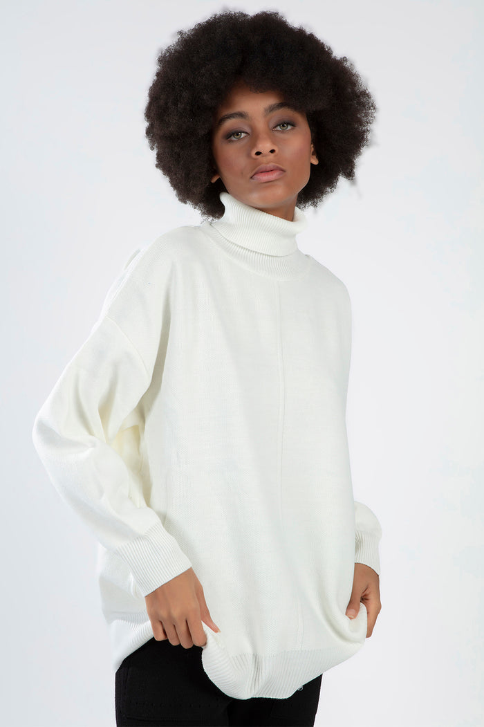 Mabel cream knit turtleneck sweater with an oversized fit and ribbed cuffs on a model.
