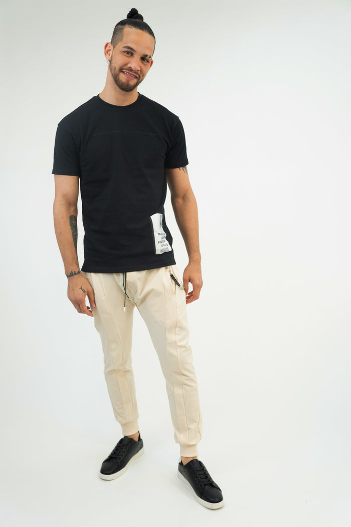 Model wearing MAC slim-fit cream joggers with drawstring waist and ribbed cuffs, styled for men's streetwear.