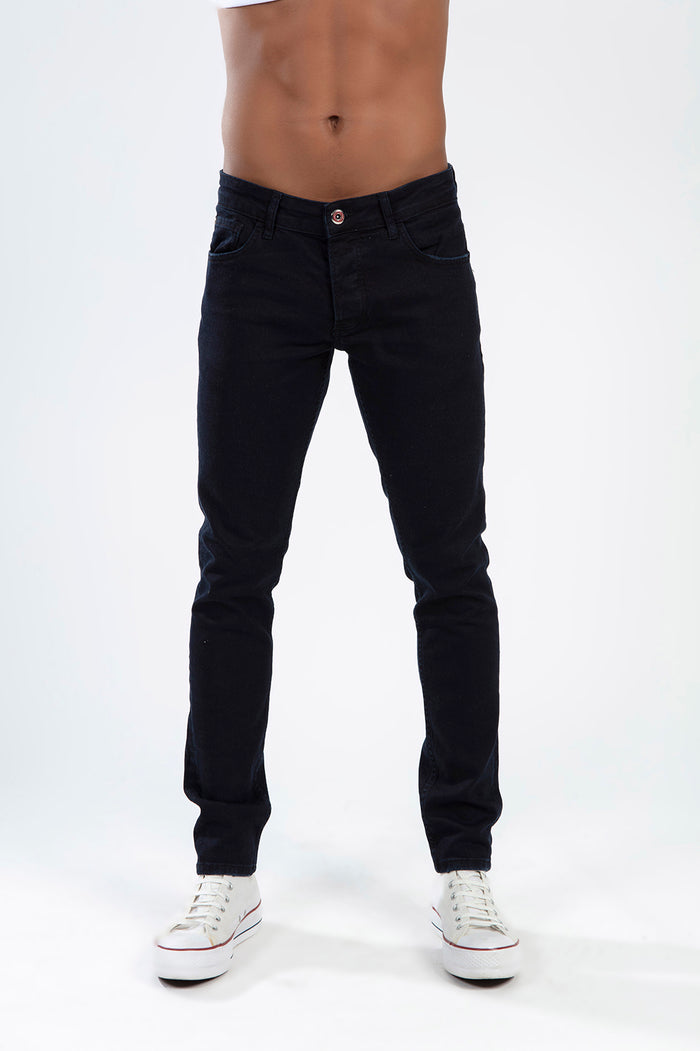 Marcus men's dark blue slim fit jeans with five-pocket styling and white sneakers on a studio background.