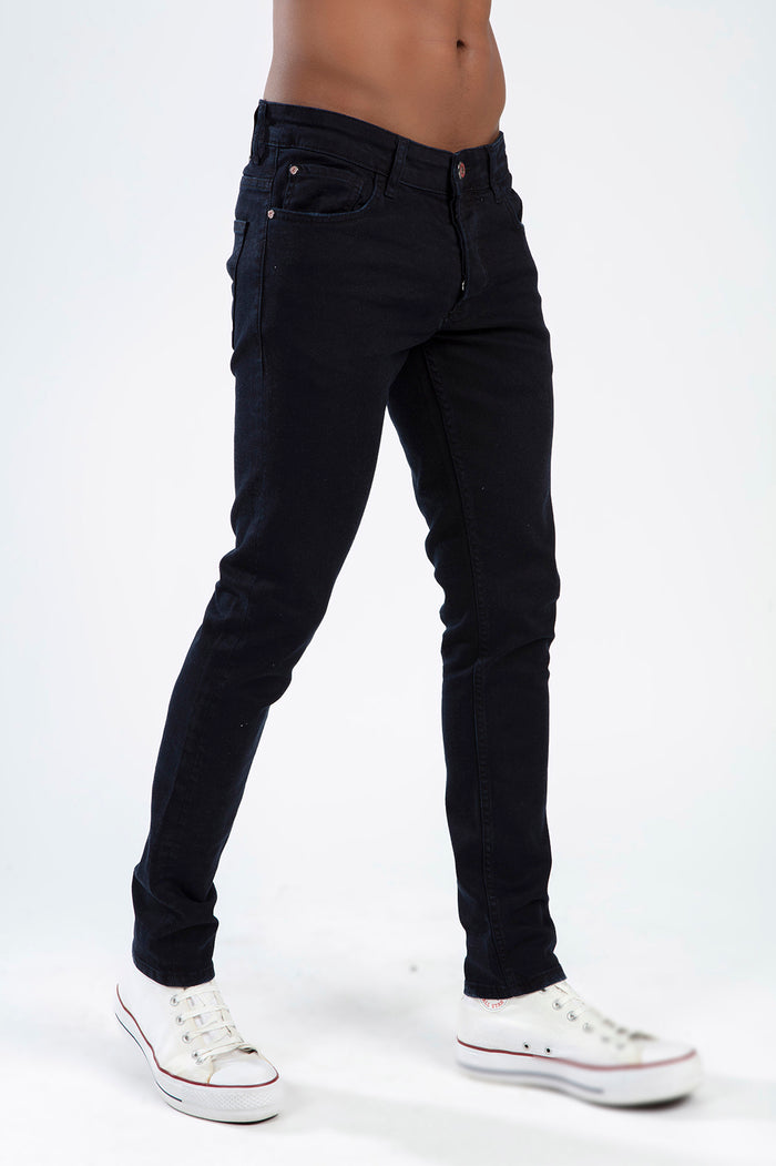 Marcus Marcus Dark Blue Men's Slim Fit Jeans by Carbon Jeans worn with white sneakers on a studio background.