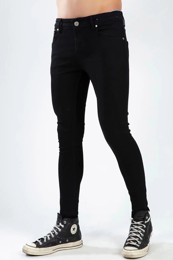 Men wearing Mark Black super skinny trendy denim jeans with black high-top sneakers against a white background.
