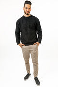 Man wearing the black Miles Top, a fuzzy textured long-sleeve crewneck sweater, paired with tan chinos.