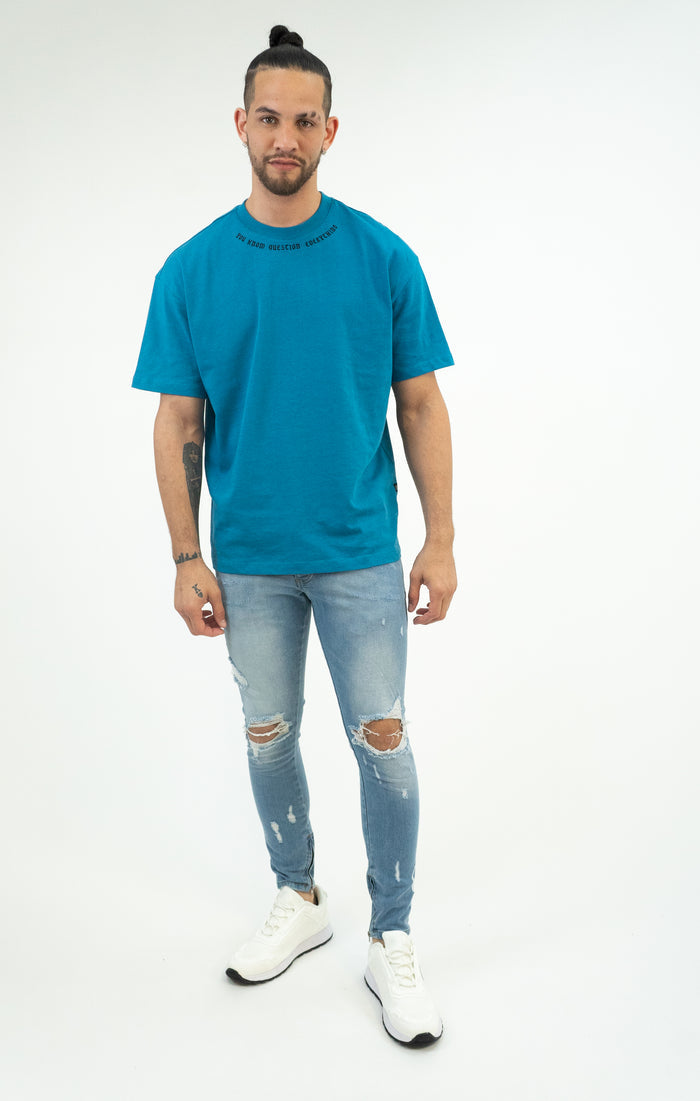 Men's Neil Jeans in light blue wash denim with distressed knees and a skinny fit on a model in a studio setting.