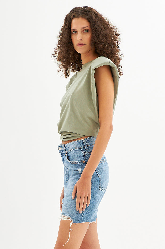 Model in Gravity Grey Padded Muscle Tee with structured shoulders and a denim skirt, streetwear style.